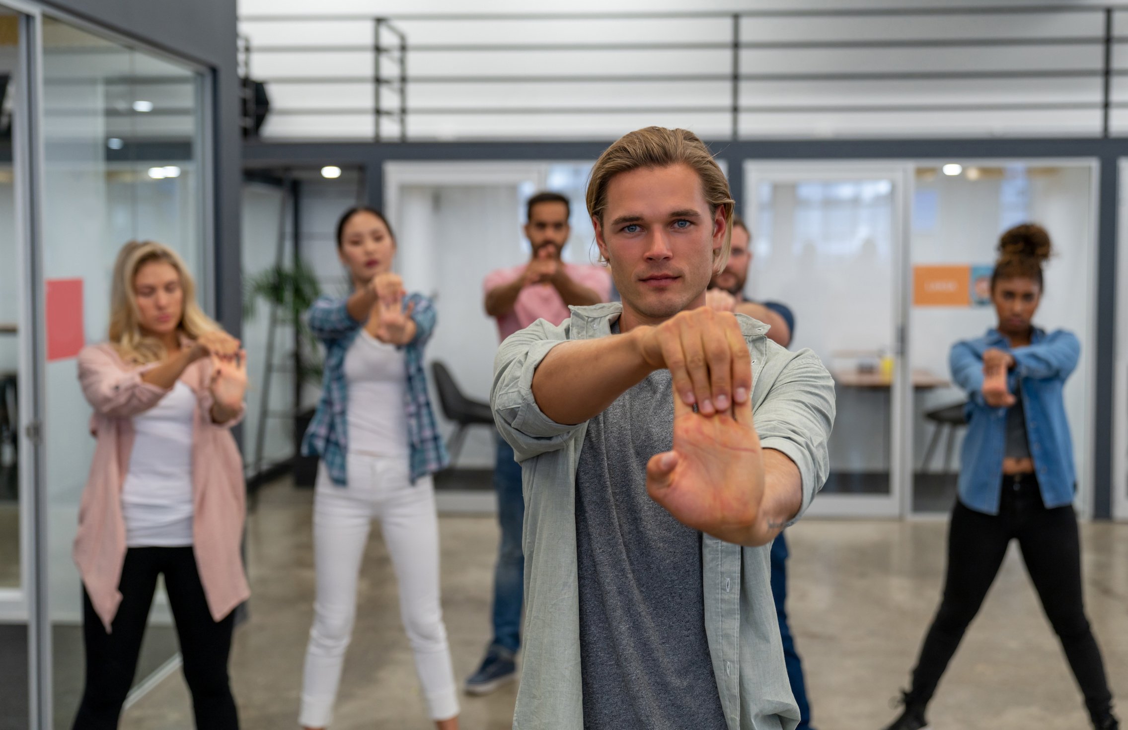 Group of coworkers stretching in an active break at the office